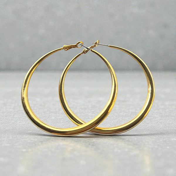 Représentation des grandes créoles dorées à l'or fin 24 carats sur fond sutudio gris