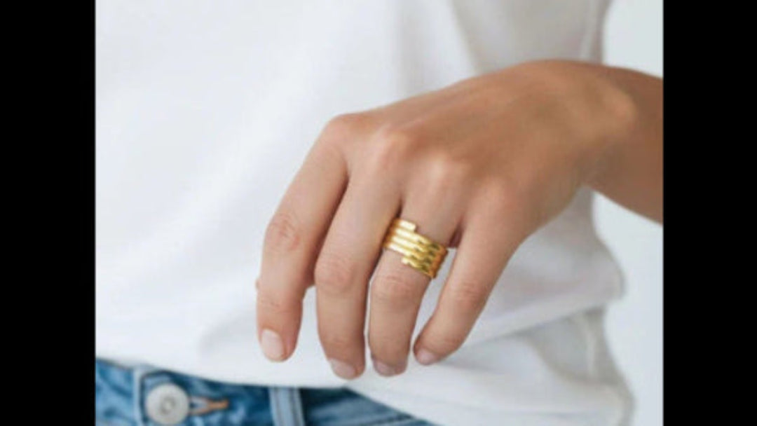 Représentation de la bague spirale dorée à l'or fin 24 carats sur le doigt d'un mannequin femme.
