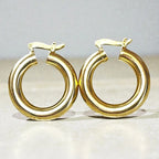 Représentation des boucles tubes dorées à l'or fin 24 carats sur fond studio