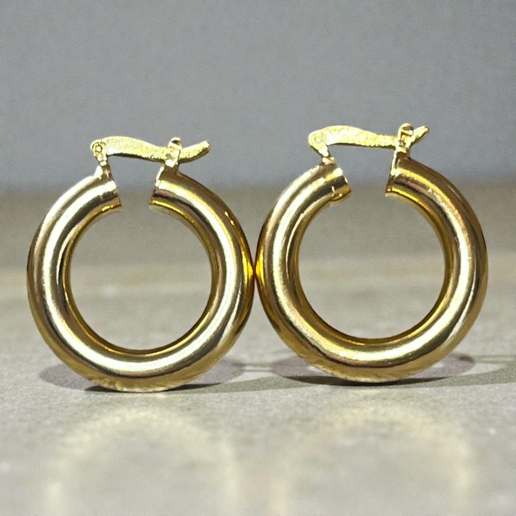 Représentation des boucles créoles tubes en gros plan sur fond studio