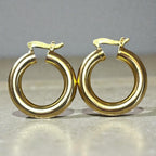 Représentation des boucles créoles tubes en gros plan sur fond studio